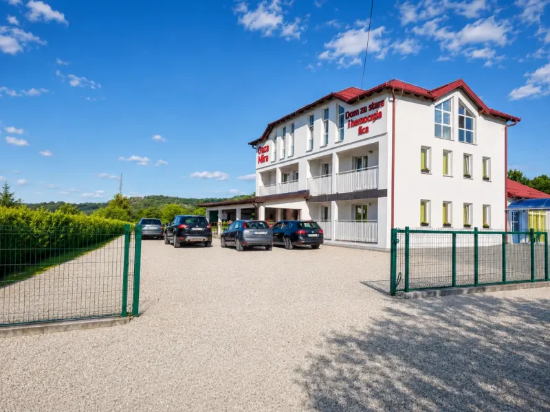 Vanjski izgled doma za starije osobe Oaza Mira s ulazom, dvorištem i parkiranim vozilima